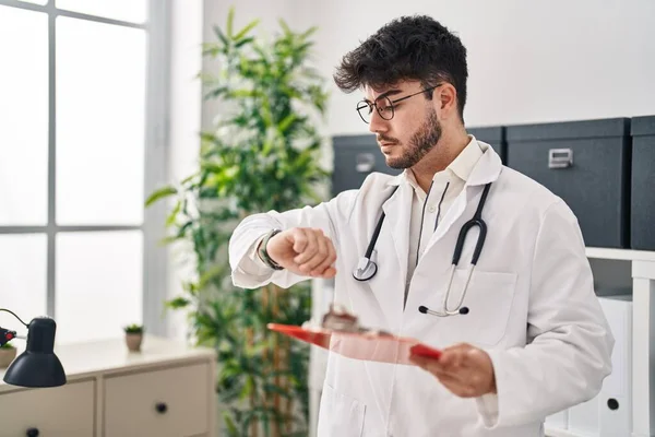 Ung Latinamerikan Man Klädd Läkare Uniform Ser Titta Hålla Rapport — Stockfoto