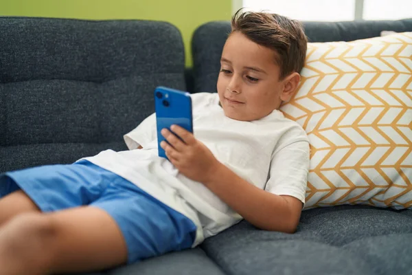 Adorável Criança Hispânica Usando Smartphone Deitado Sofá Casa — Fotografia de Stock