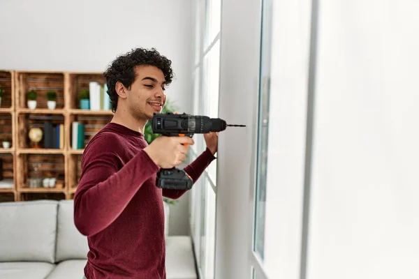 Joven Hombre Hispano Sonriendo Feliz Perforando Pared Casa — Foto de Stock