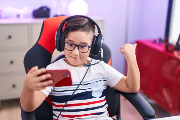 Young Hispanic Kid Playing Video Games Smartphone Pointing Thumb Side — Stok fotoğraf