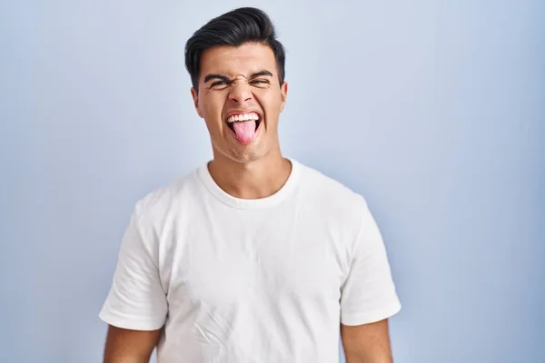Hispanic Man Står Över Blå Bakgrund Sticker Tungan Nöjd Med — Stockfoto