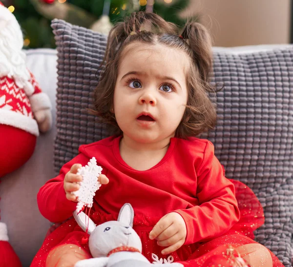 Αξιολάτρευτο Ισπανόφωνο Κορίτσι Κάθεται Στον Καναπέ Δίπλα Στο Χριστουγεννιάτικο Δέντρο — Φωτογραφία Αρχείου