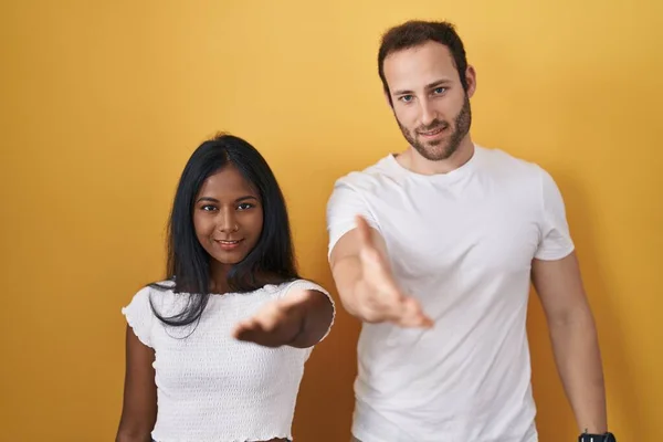 Interracial Couple Standing Yellow Background Smiling Cheerful Offering Palm Hand — 图库照片