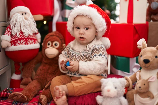 愛らしいCaucasian赤ん坊遊びとともに車おもちゃで床に座ってクリスマスプレゼントによって家 — ストック写真