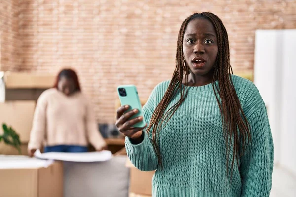 Mujer Africana Usando Teléfono Inteligente Nuevo Hogar Asustado Sorprendido Con —  Fotos de Stock