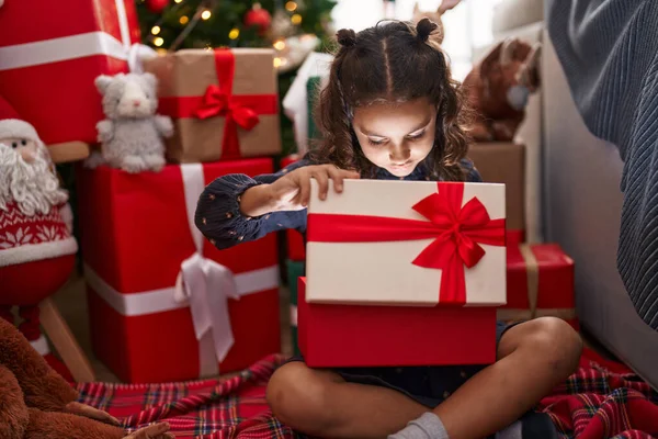 Adorable Hispanic Girl Unpacking Gift Sitting Floor Christmas Tree Home — 스톡 사진