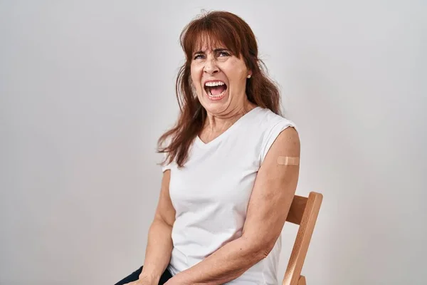 Middle Age Hispanic Woman Getting Vaccine Showing Arm Band Aid — Stockfoto