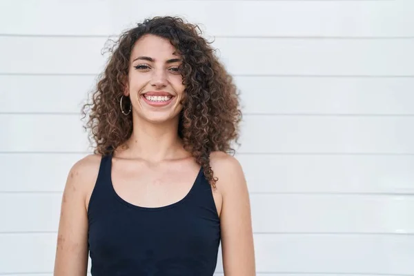 Beyaz Arka Planda Duran Kıvırcık Saçlı Spanyol Kadın Pozitif Mutlu — Stok fotoğraf