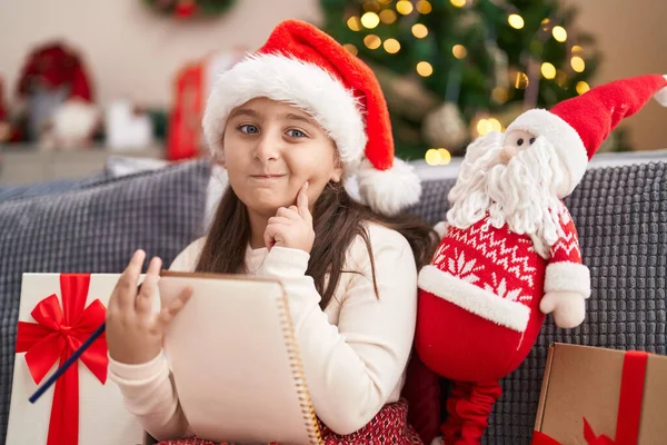 Rozkošná Hispánská Dívka Sedí Pohovce Vánočního Stromku Pochybnostmi Výraz Doma — Stock fotografie