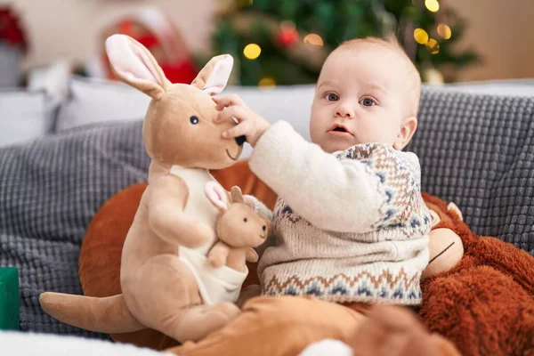 Adorável Bebê Caucasiano Segurando Boneca Canguru Sentado Sofá Pela Árvore — Fotografia de Stock