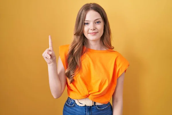 Caucasian Woman Standing Yellow Background Showing Pointing Finger Number One —  Fotos de Stock