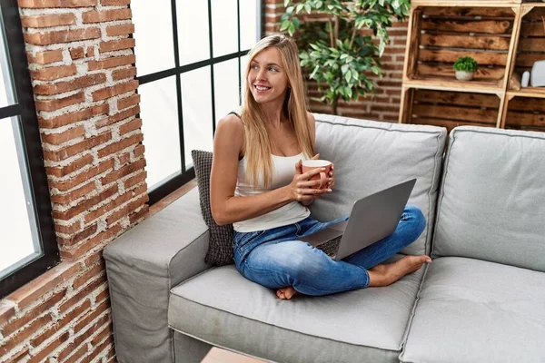 Ung Blond Kvinna Som Använder Laptop Och Dricker Kaffe Sitter — Stockfoto