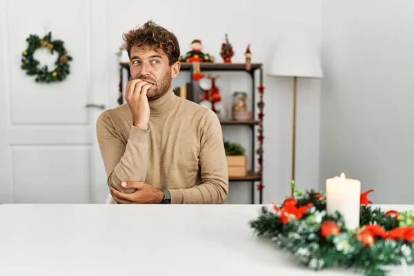 Young Handsome Man Beard Sitting Table Christmas Decoration Looking Stressed — Stok fotoğraf