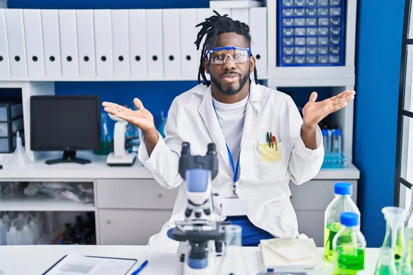 科学研究所で働いている恐ろしいロックを持つアフリカの男は大声で叫び 口に手をつないで大声で叫んでいます コミュニケーションの概念 — ストック写真