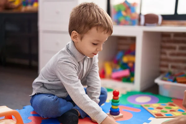 可爱的幼儿坐在幼儿园的地板上玩数学游戏 — 图库照片