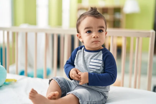 可爱的惊慌失措的幼儿坐在摇篮上 在卧室里轻松的表情 — 图库照片