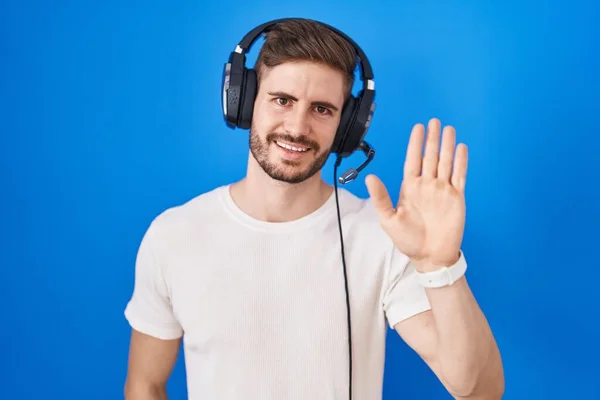 Hispanic Man Beard Listening Music Wearing Headphones Waiving Saying Hello — Stockfoto