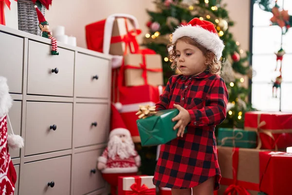 可爱的高加索女孩持着礼物站在家里的圣诞树旁 — 图库照片