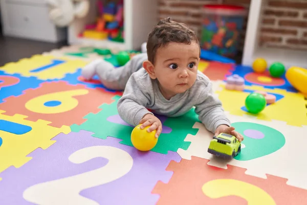幼稚园里 他那可爱的惊慌小宝宝躺在地板上玩着球和车 — 图库照片