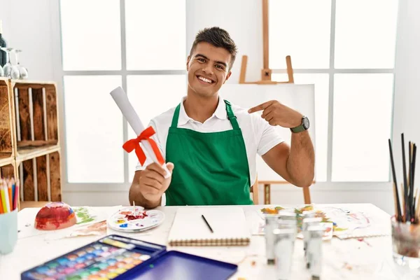 Young Hispanic Man Art Studio Holding Degree Looking Confident Smile — Stok fotoğraf