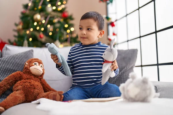 Sevimli Spanyol Bebek Evdeki Noel Ağacının Yanında Koltukta Oyuncaklarla Oynuyor — Stok fotoğraf