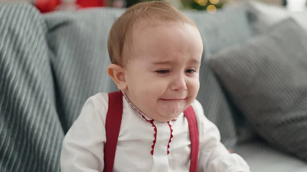Adorable Hispanic Baby Sitting Sofa Christmas Tree Crying Home — стоковое фото