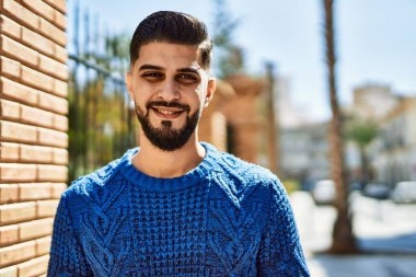 Sokakta kendinden emin gülümseyen genç bir Arap.