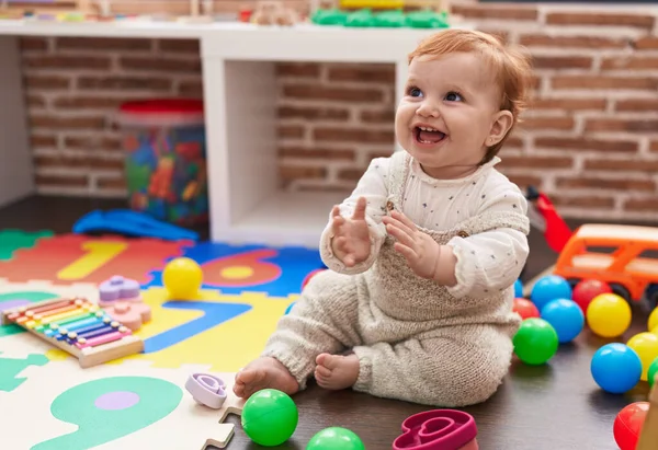 Liebenswertes Rothaariges Kleinkind Sitzt Auf Dem Boden Und Applaudiert Kindergarten — Stockfoto