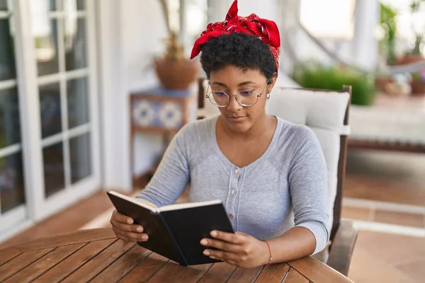 African American Woman Reading Book Sitting Table Home Terrace —  Fotos de Stock