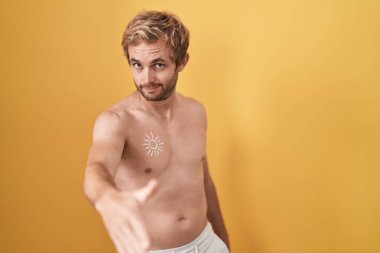 Caucasian man standing shirtless wearing sun screen smiling friendly offering handshake as greeting and welcoming. successful business. 