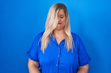 Caucasian plus size woman standing over blue background depressed and worry for distress, crying angry and afraid. sad expression. 
