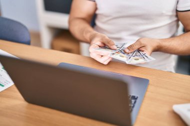 Genç İspanyol iş adamı ofiste çalışan paraları sayıyor.