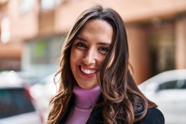 Sokakta kendine gülen genç İspanyol kadın.