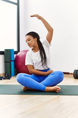 Genç Afrikalı Amerikalı kadın spor merkezinde geriniyor.