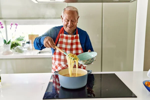 Hombre Mayor Sonriendo Confiado Cocinando Espaguetis Cocina —  Fotos de Stock