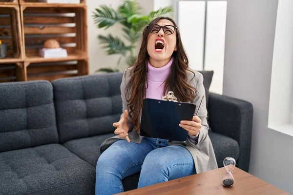Young Brunette Woman Working Consultation Office Angry Mad Screaming Frustrated — Fotografia de Stock