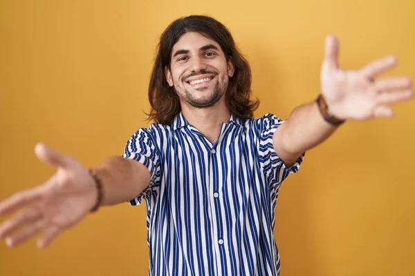 Hispanic Man Long Hair Standing Yellow Background Looking Camera Smiling — Foto de Stock
