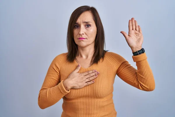 Middle Age Brunette Woman Standing Wearing Orange Sweater Swearing Hand — Photo