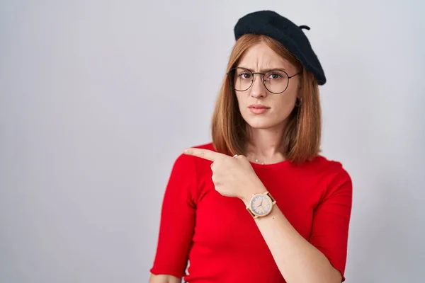 Młoda Ruda Kobieta Stojąca Okularach Berecie Odsunięta Bok Zmartwiona Zdenerwowana — Zdjęcie stockowe
