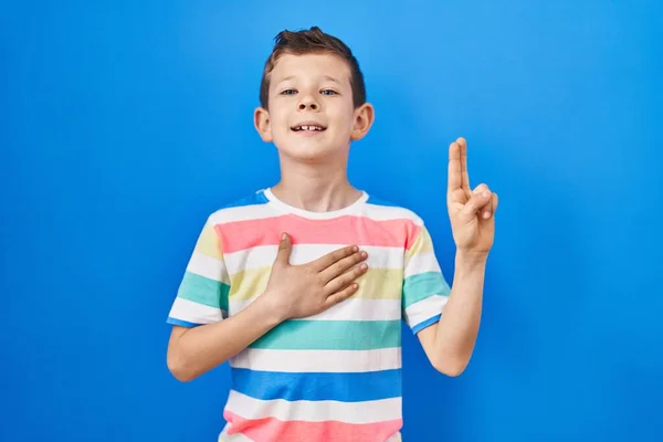 Young Caucasian Kid Standing Blue Background Smiling Swearing Hand Chest — Stockfoto