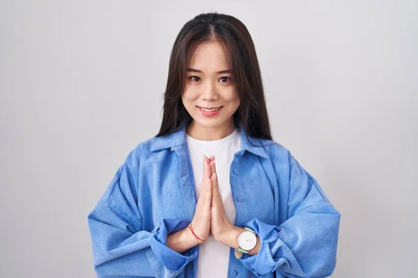Ung Kinesisk Kvinna Står Över Vit Bakgrund Med Händerna Tillsammans — Stockfoto