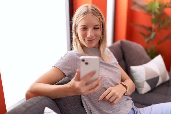 Jovem Loira Usando Smartphone Sentado Sofá Casa — Fotografia de Stock