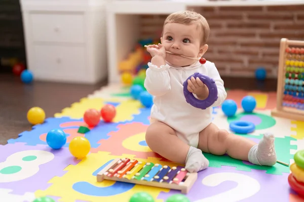 Sevimli Bebek Ksilofon Çubuğunu Isırıyor Anaokulunda Yerde Oturuyor — Stok fotoğraf
