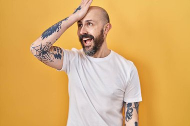 Sarı arka planda dikilen İspanyol dövmeli genç adam hata yaptığında şaşırdı. Hatayı hatırla. Unuttum, kötü hafıza kavramı. 