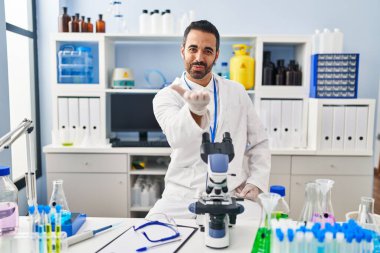 Sakallı, bilim adamı laboratuvarında çalışan genç İspanyol bir adam kameraya bakıp havada öpüşüyor ve güzel ve seksi oluyor. aşk ifadesi. 