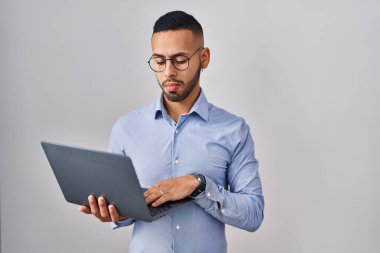 Young hispanic man working using computer laptop depressed and worry for distress, crying angry and afraid. sad expression. 