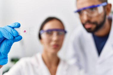 Man and woman scientist partners looking sample working at laboratory