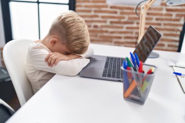 Sevimli çocuk sınıfta masada otururken dizüstü bilgisayar kullandığını vurguladı.