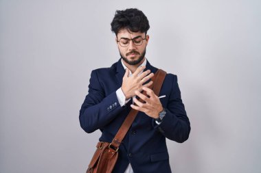 Sakallı İspanyol bir adam iş kıyafetleri giyiyor. Ellerinde ve parmaklarında ağrı var. Eklem iltihabı. 