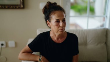 Orta yaşlı İspanyol kadın aile içi şiddet yüzünden acı çekiyor. Gözlerinde morluklar var.